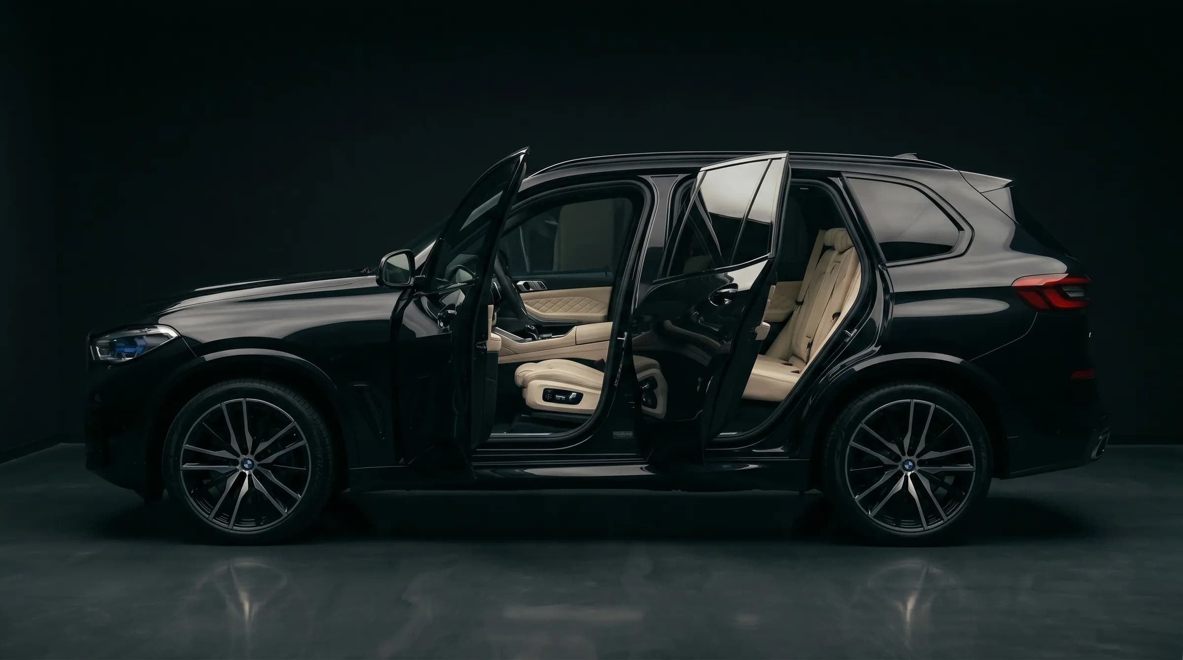 Передний ряд BMW X5 после премиум-химчистки — кожаные сиденья, чистый потолок и панель